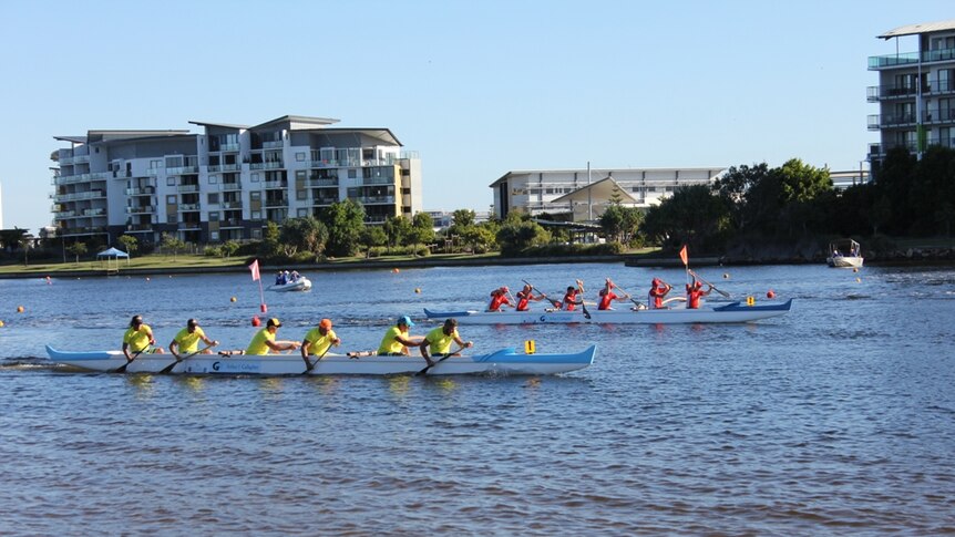 Two six-person outriggers head to the finish line at Lake Kawana.