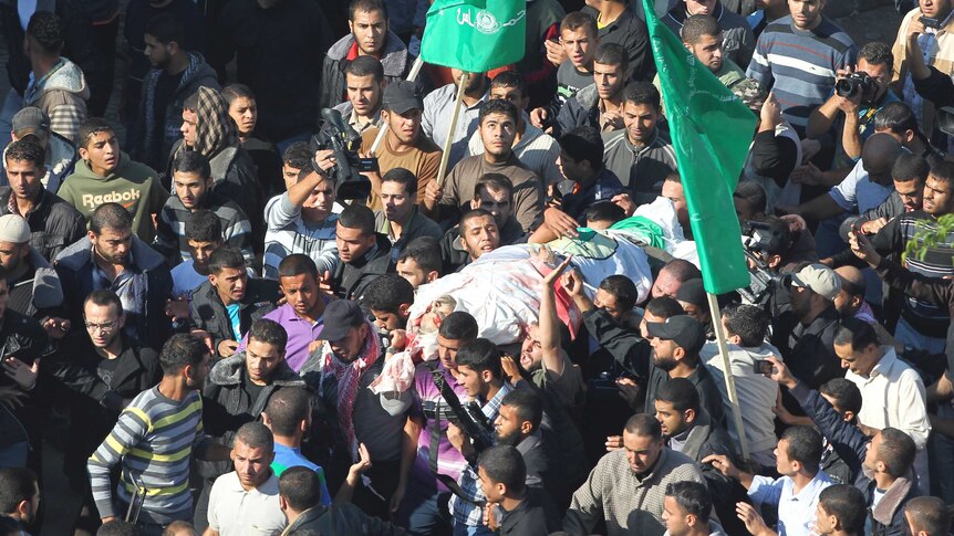 Palestinians carry the body of Ahmed Al-Jaabari, top commander of Hamas armed wing Izz el-Deen Al-Qassam.