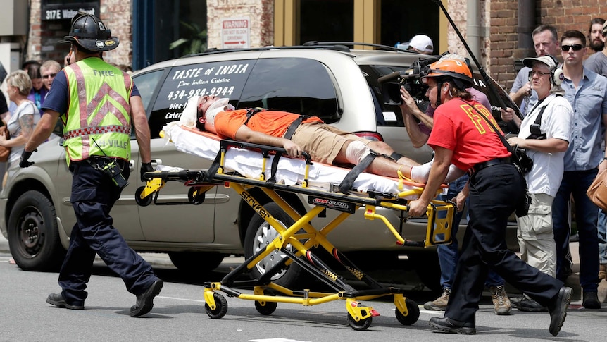 Emergency crews wheel an injured man on a trolley.