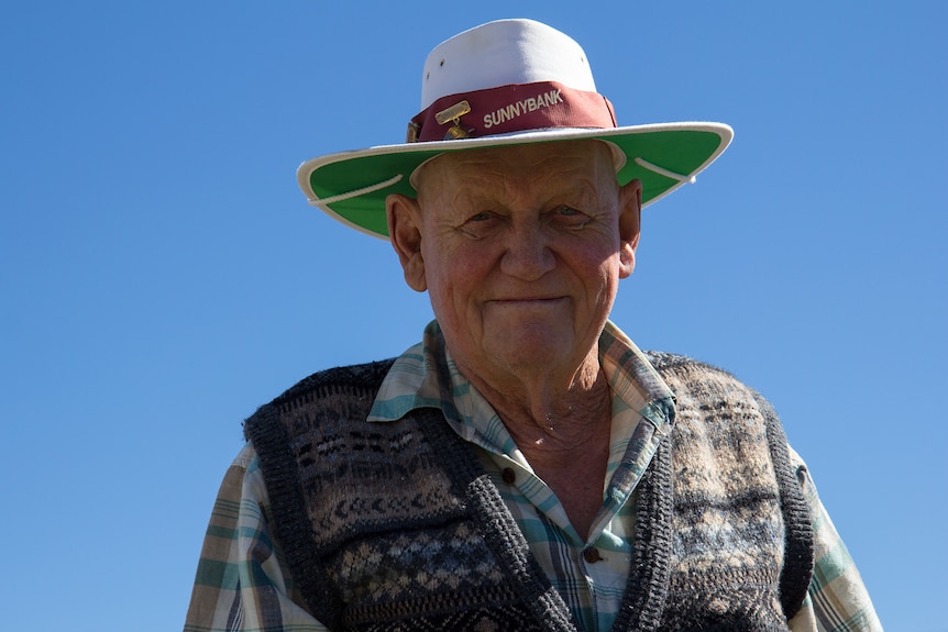 Older bowler at Sunnybank Bowls Club wearing a club hat.