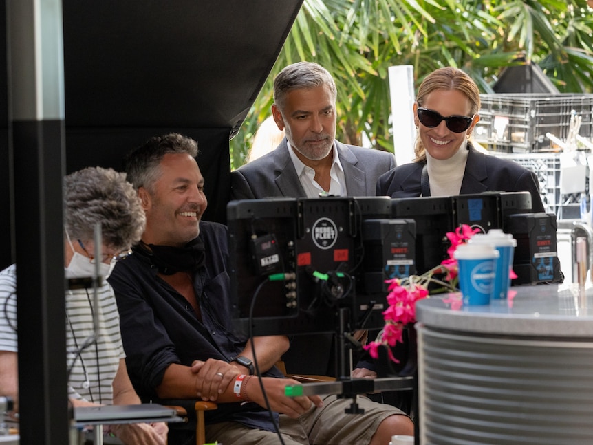 Julia Roberts and George Clooney watch screens with director on set