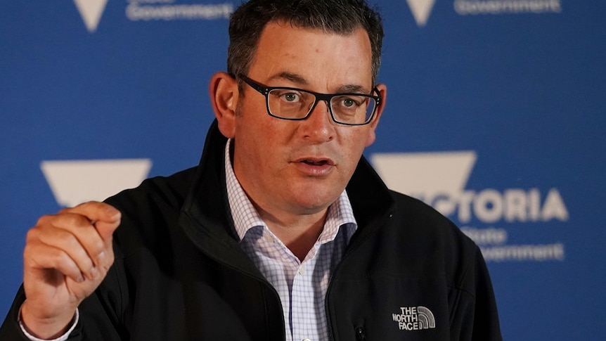 Daniel Andrews peaks at a press conference.