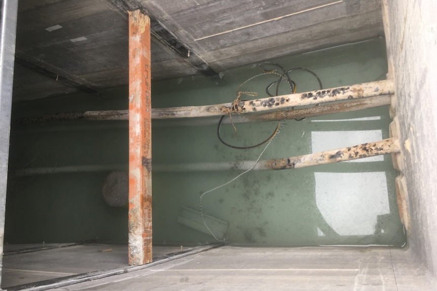 Looking down a hole at flooded electrical pits on a construction site for light rail.