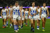 A group of North Melbourne AFL players leave the field during a match against Fremantle.