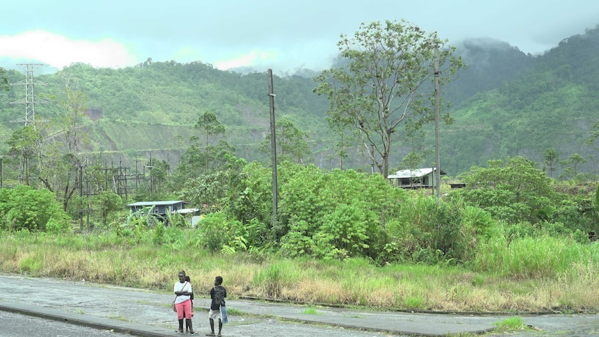 Bougainville locals stand near the open mine pit in Bougainville