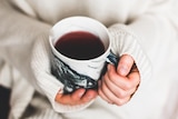 A person holding a cup of tea