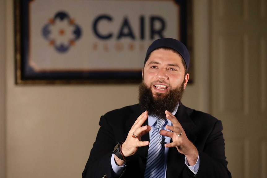 Hassan Shibly sitting and speaking.