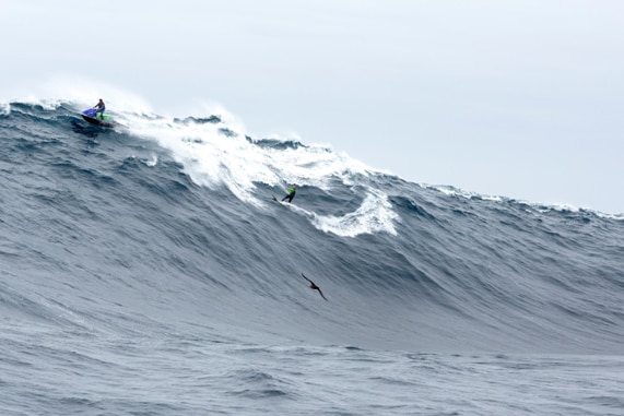 A surfer is towed onto a wave at Pedra Branca