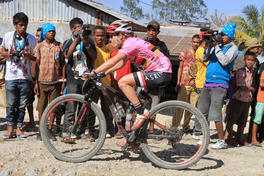 Leading woman rider and 3rd place overall Catherine Williamson climbs past local media crews