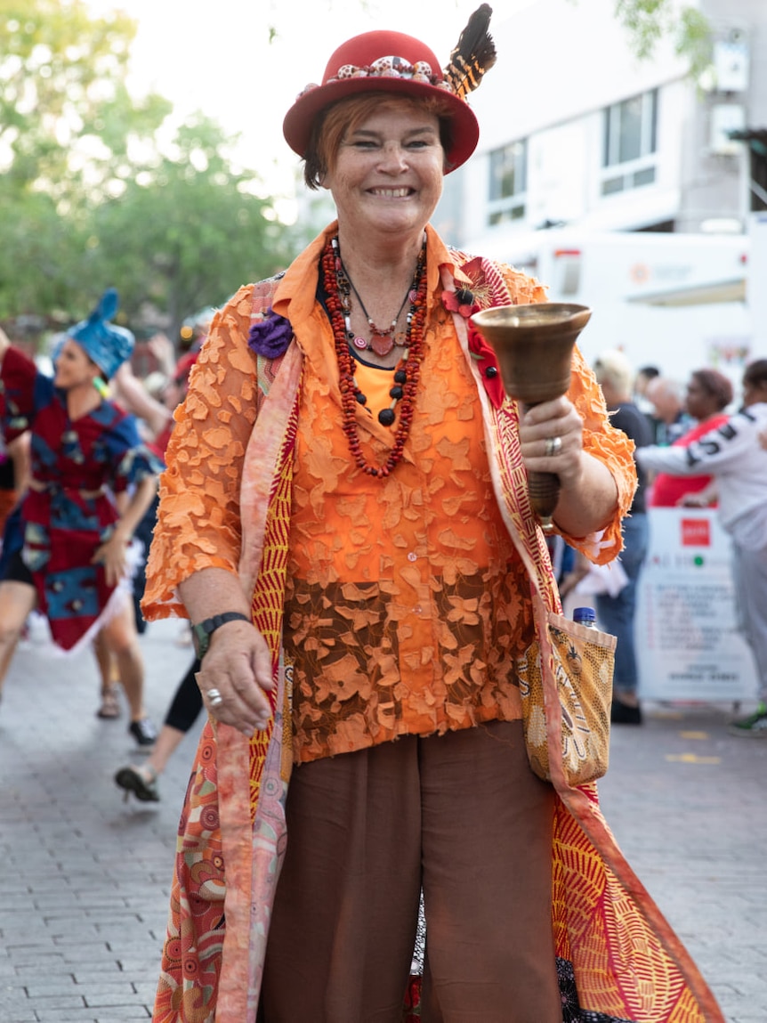 woman with hat leading a parade wearing town crier garb