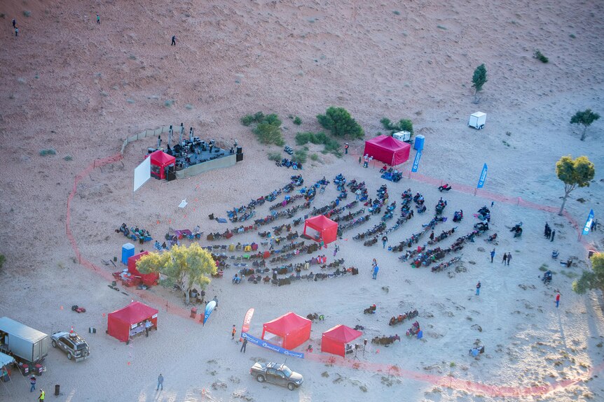 A birds-eye view of a small music festival in the desert.