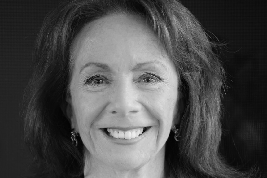 A black and white headshot of a woman wearing a suit. 