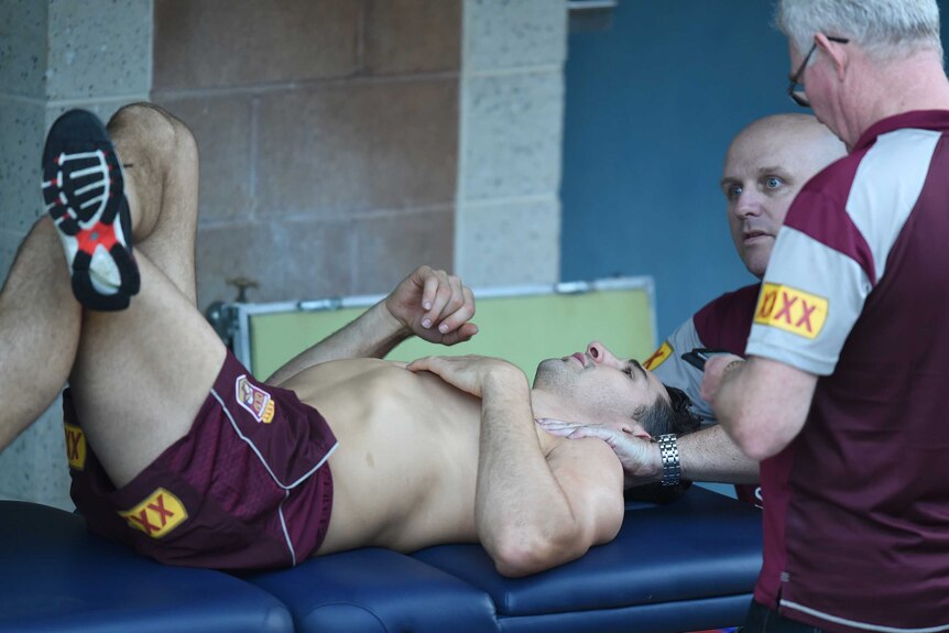 Billy Slater receives treatment on his injured shoulder