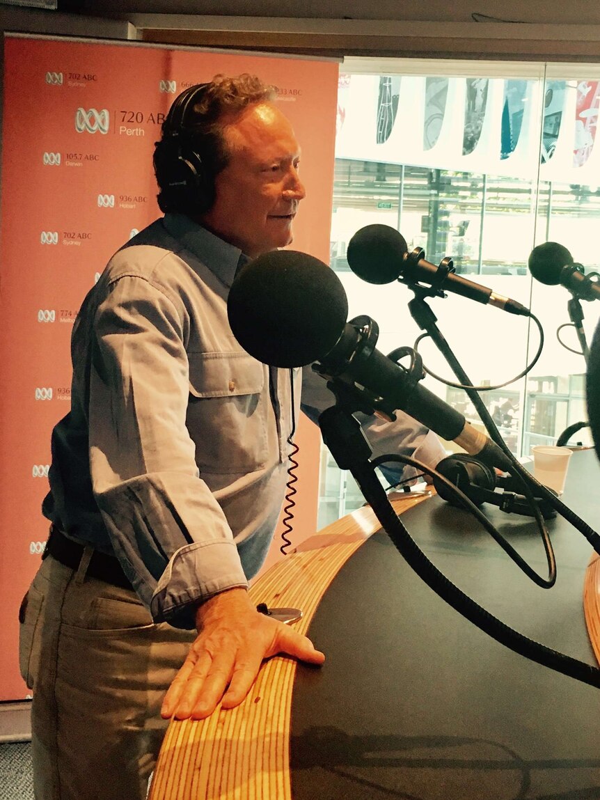 Andrew Forest in front of a few mics, with headphones on, ABC 720 studio. WA of the year 2016