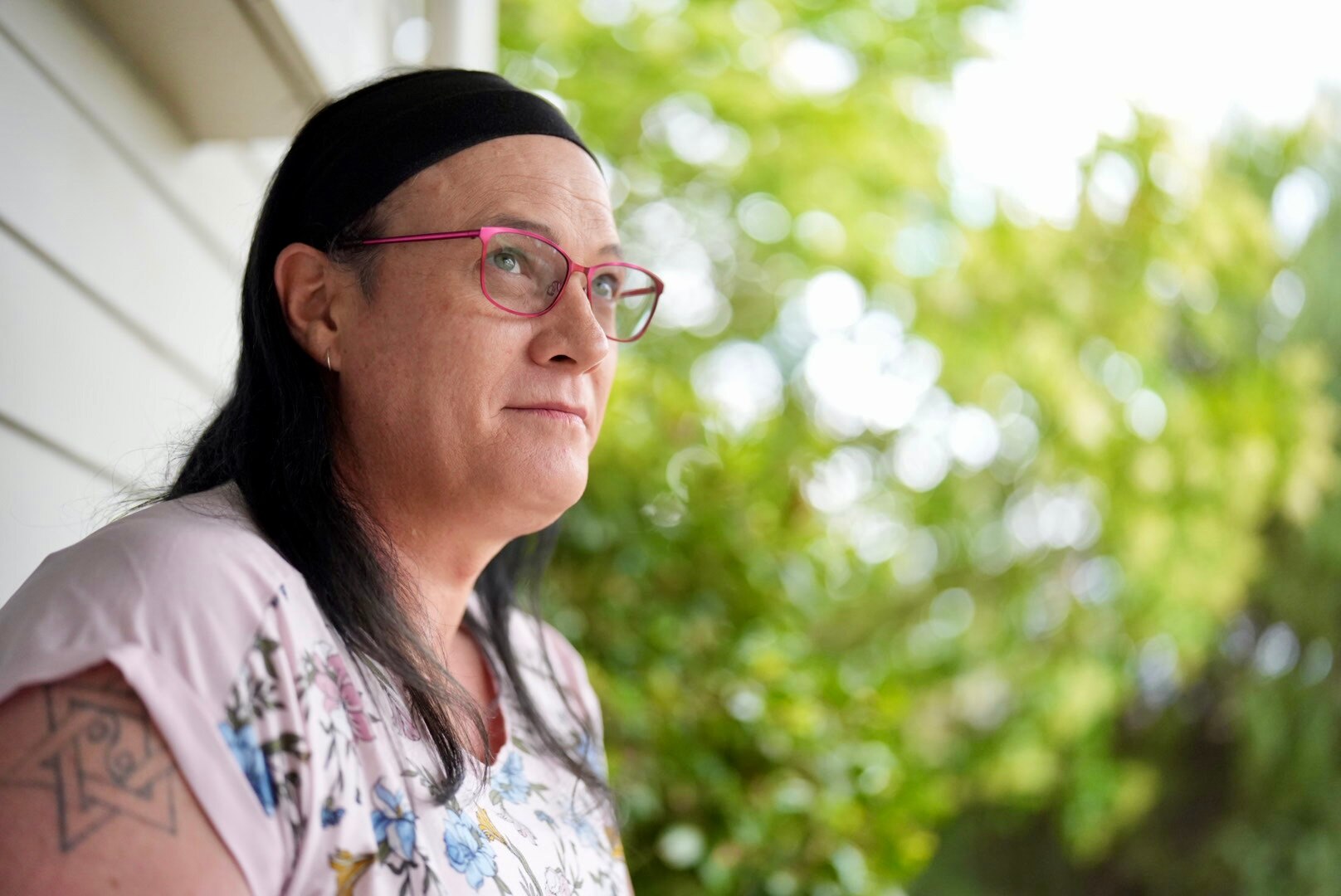 Una mujer con gafas rosas y una diadema negra.