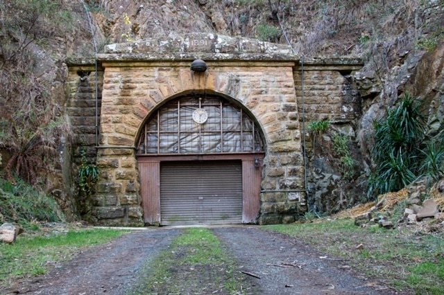 A railway tunnel with a roller door as its entrance and the date '1891' at the top