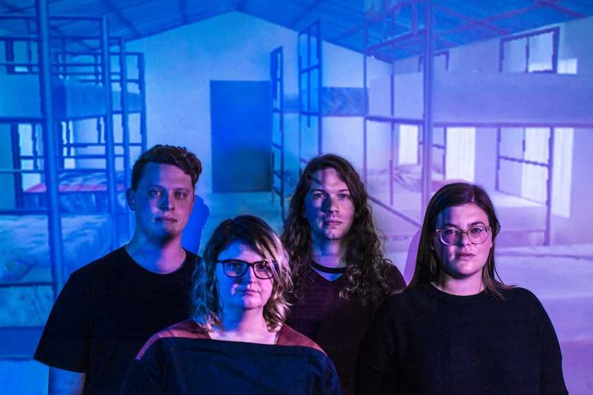 Colour photo of Applespiel artists Nathan Harrison, Emma McManus, Simon Vaughan and Rachel Roberts infront of projection.