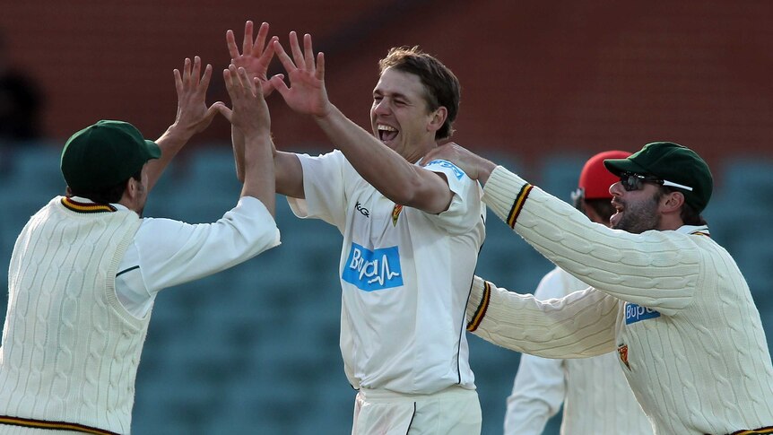 On fire ... Luke Butterworth (C) celebrates a dismissal with his team-mates