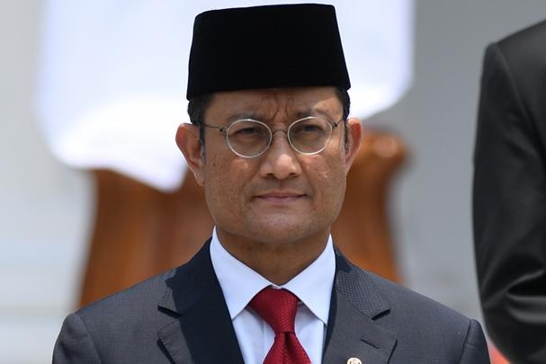 Indonesian social affairs minister Juliari Batubara wears a suit and traditional hat
