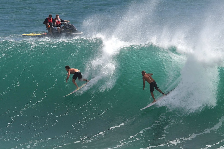 Two Surfers ride a large wave at Kirra on the Gold Coast.
