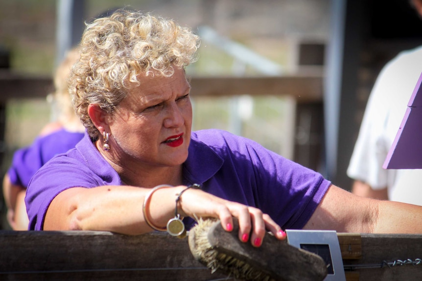 Sunshine Butterflies founder Leanne Walsh on the farm, holding an animal brush.