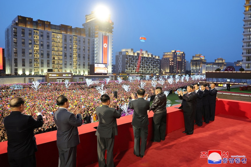 North Korean leader Kim Jong Un attends a completion ceremony for a residential development in front of an enormous crowd.