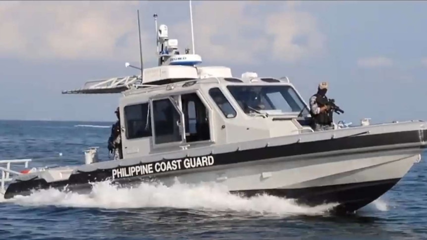 A Philippine Coast Guard boat at sea with armed officers aboard.