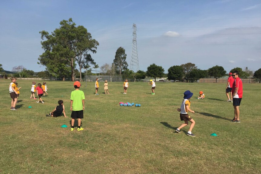 Kids practice football in a suburb of Logan.