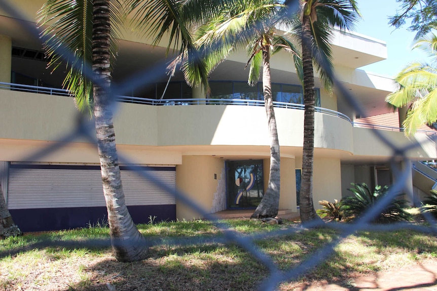 Looking through a fence at the former entrance to a closed resort.