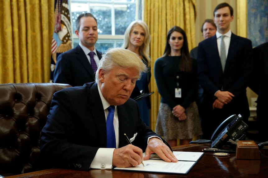 US President Donald Trump signs an executive order in the White House.