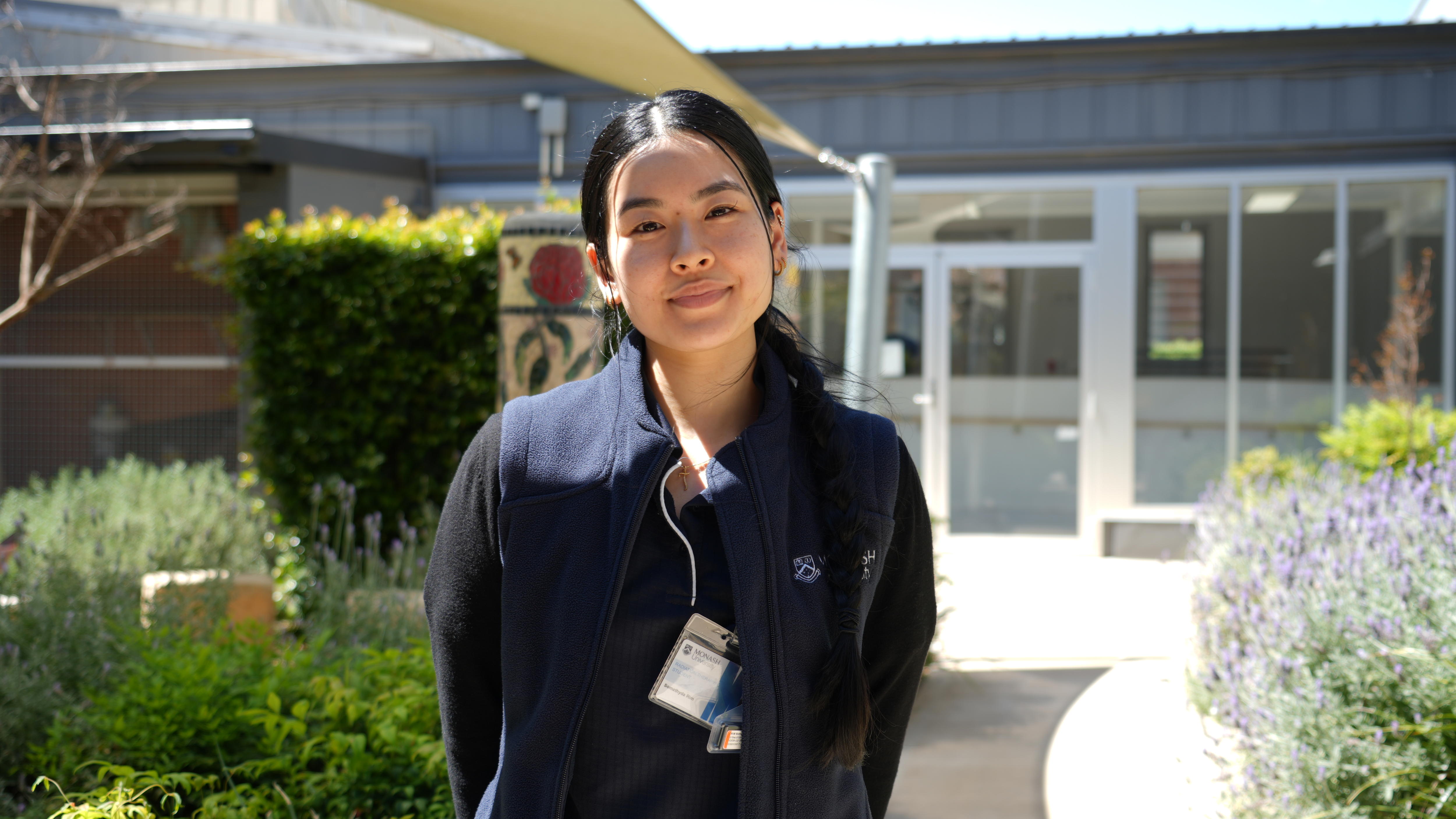 Ms Rim is standing in a hospital garden looking happy