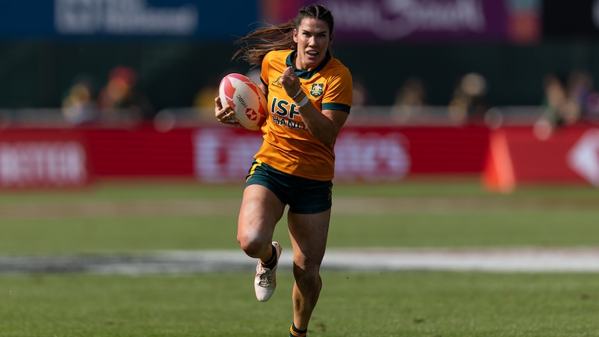 Charlotte Caslick running with the ball at the 2023 Dubai Sevens.