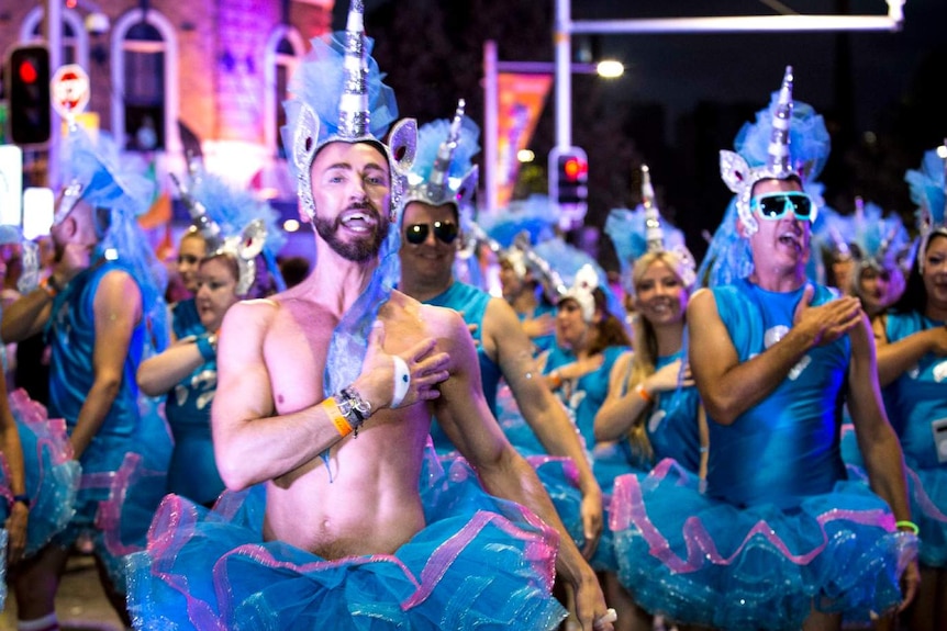 Men dance in blue costumes and unicorn horns at Sydney Mardi Gras