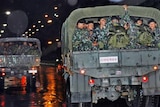 Army trucks carry soldiers to take positions at the government installations in Bangkok.