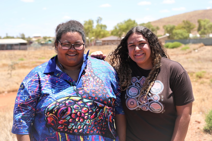 Two women smiling at the camera. 