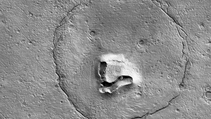 A photo of a crater shaped like a bear's face on the surface of Mars