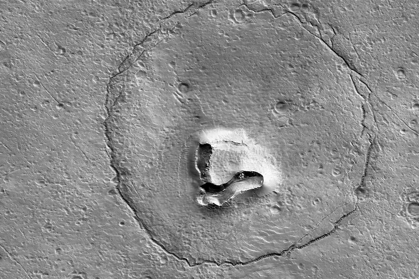 A photo of a crater shaped like a bear's face on the surface of Mars