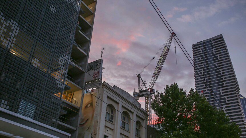 Crane on Melbourne construction site at sunrise
