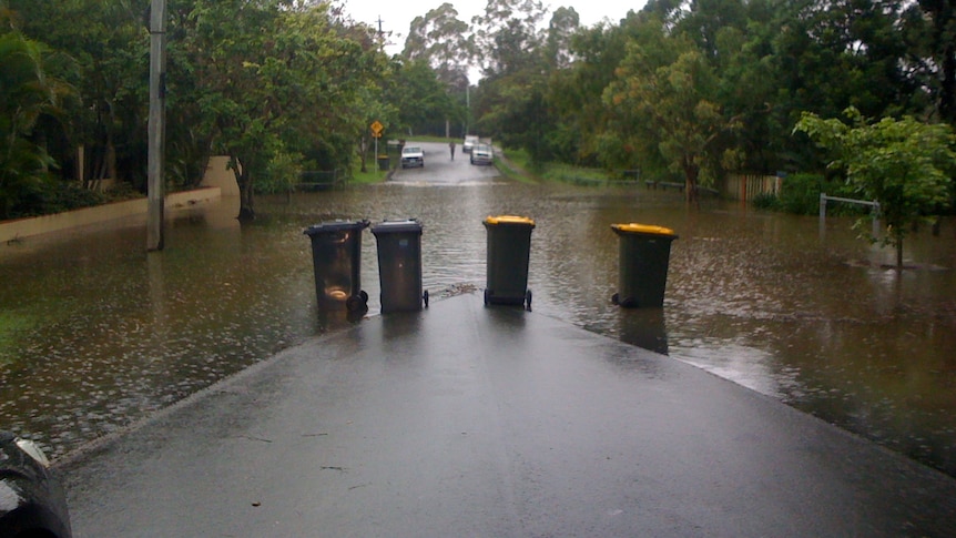 Wheelie bins block road as waters start rising