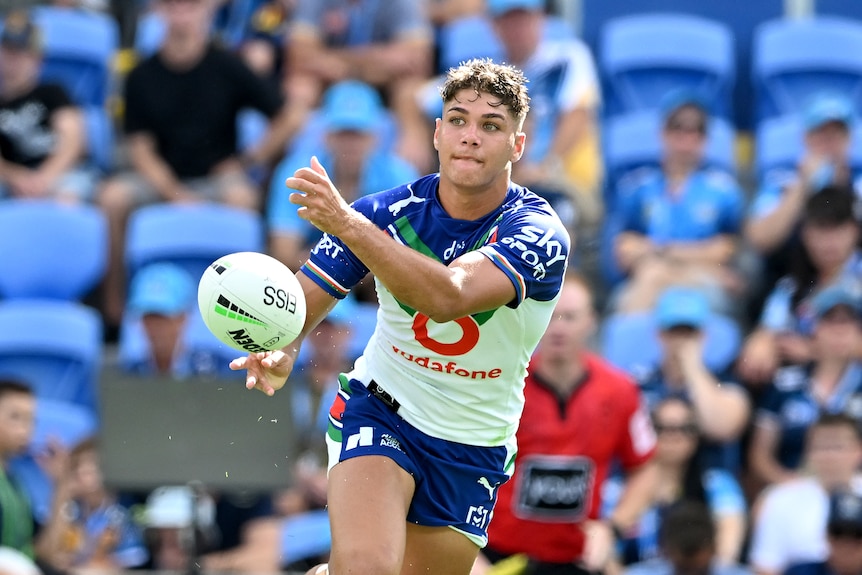 A Warriors NRL player passes to his right during a match against the Titans.