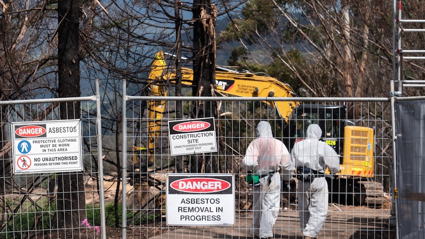 A digger clearing rubble from the remains of a house destroyed by a bushfire near Lithgow