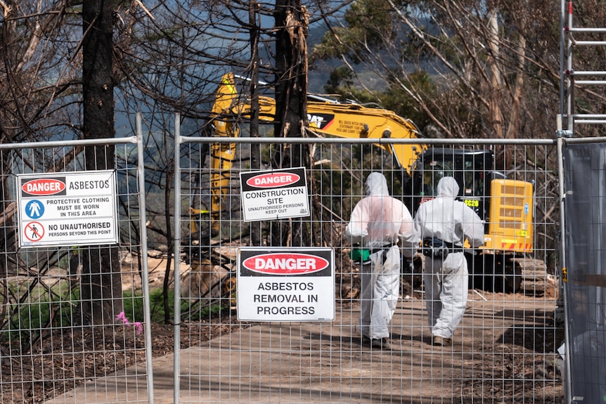 A digger clearing rubble from the remains of a house destroyed by a bushfire near Lithgow