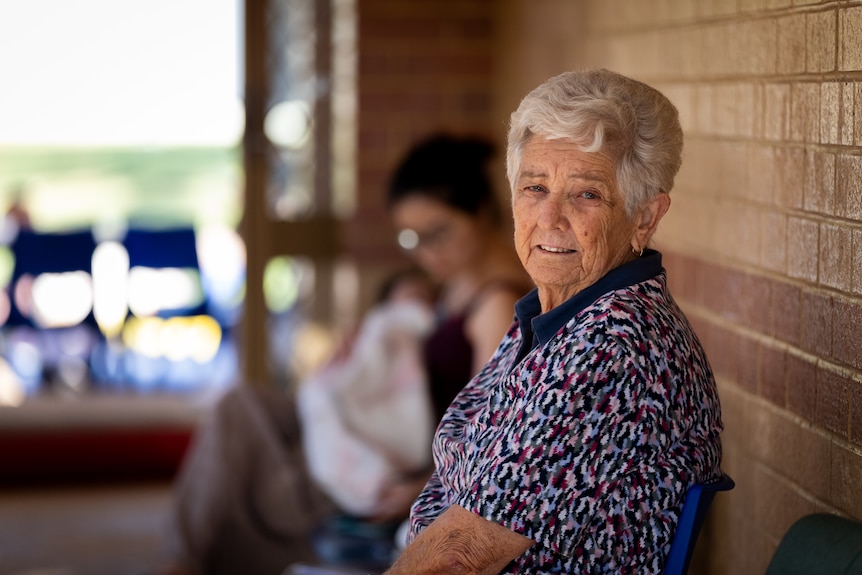An older woman looks at the camera