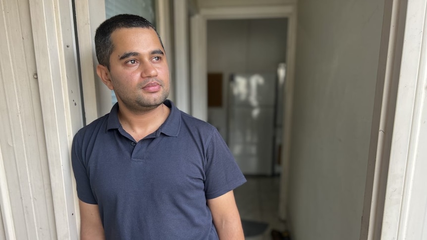 A man leaning against a doorframe