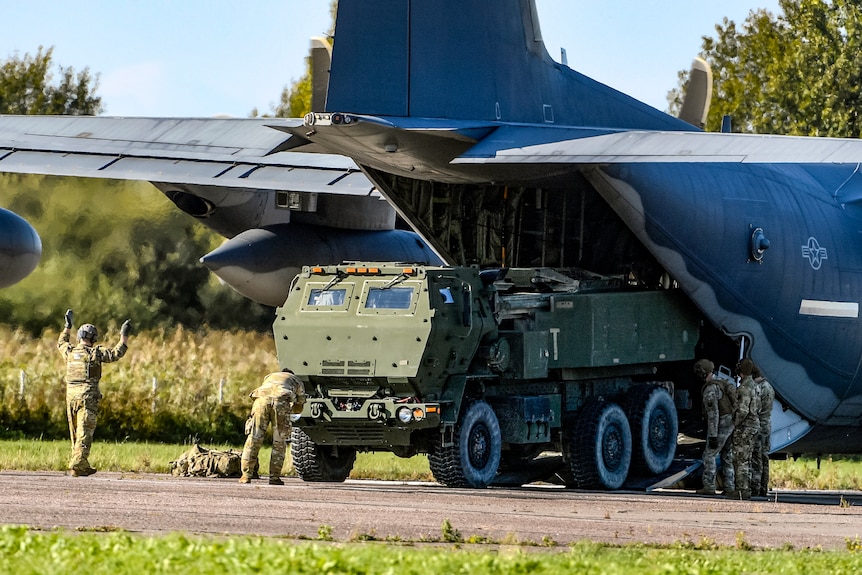 Soldiers load a High-Mobility Artillery Rocket System (HIMARS ) from a US aircraft