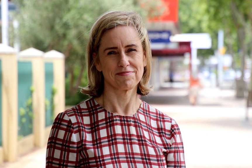 Ms McGurk stands on the street, smiling, looking into the camera 