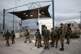 Israeli soldiers stand guard at a checkpoint near a West Bank settlement.