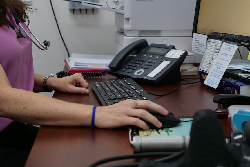 Close up of doctor sitting at desk using computer