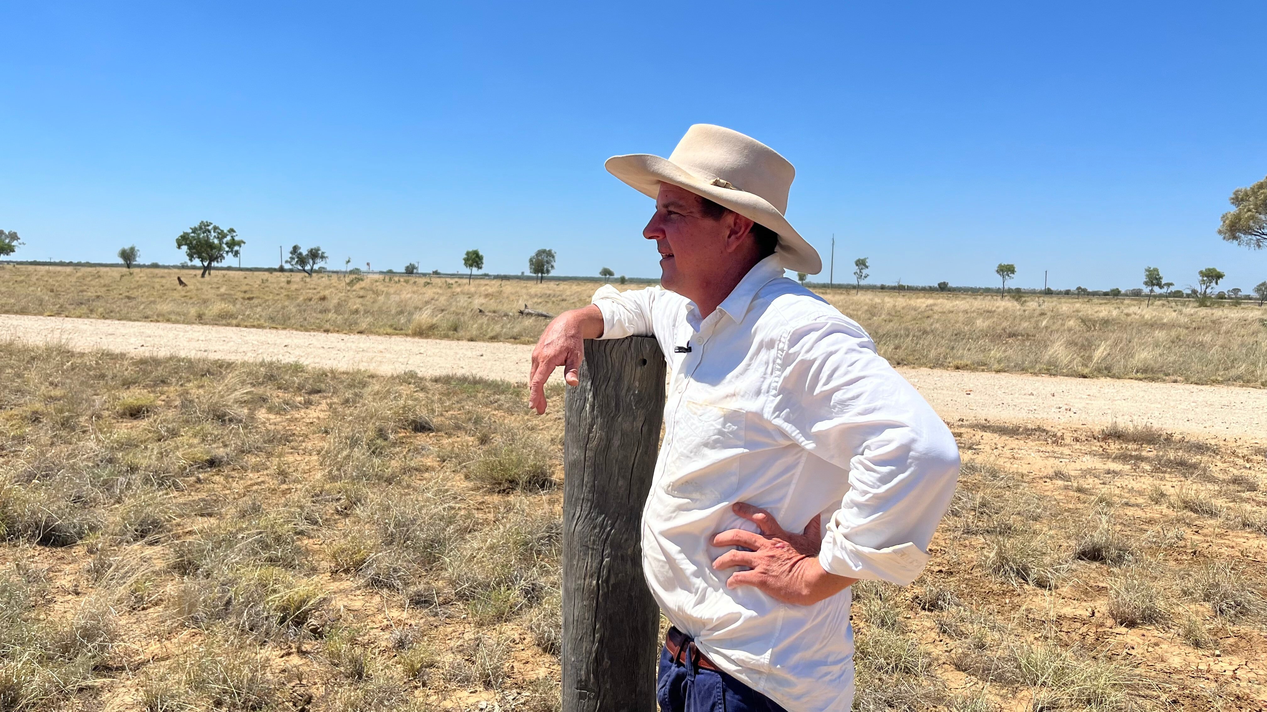 Grazier leaning on wooden fence post outback Queensland