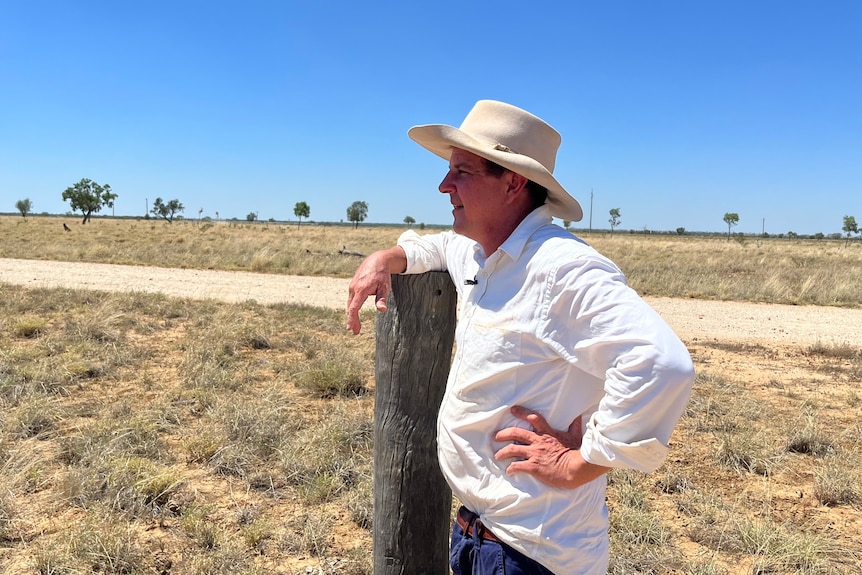Grazier leaning on wooden fence post outback Queensland